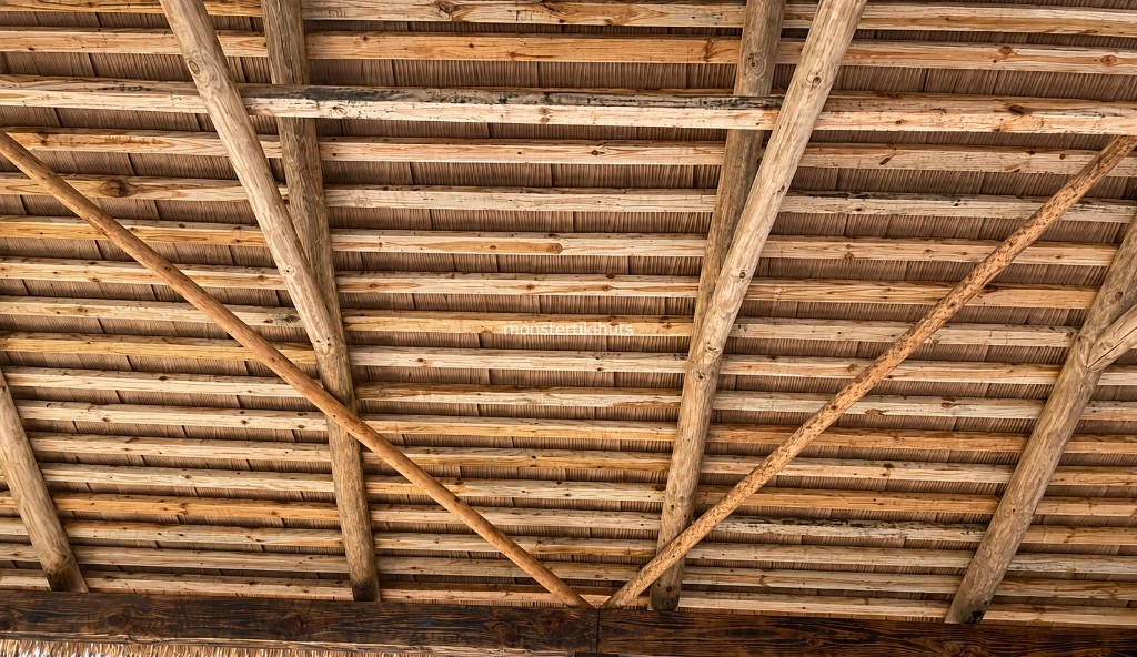 Folded synthetic thatch interior with diagonal roof bracing